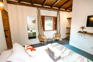 a room with a bed and a couch and a window at Aroeira Pousada in Trancoso +64 photos