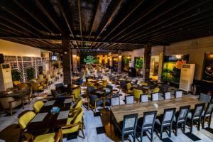 a restaurant with wooden tables and yellow chairs at Mora Hotel By Pioneer in Jeddah