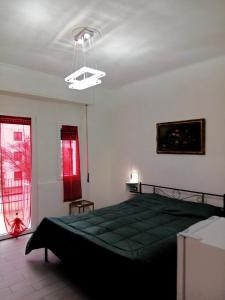 Un dormitorio con una cama verde y una ventana. en Eros casa, en Milán