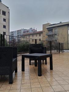 un banco y sillas en un balcón con edificios en Eros casa, en Milán