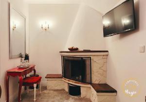 a living room with a television above a fireplace at Carpathia Magic -adults only in Peştera