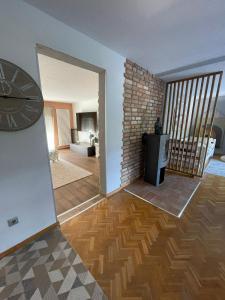 a room with a clock on the wall and a living room at Ferienwohnung Uchtelfangen in Illingen