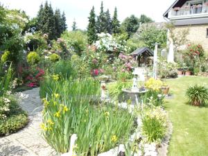 a garden with flowers and a fountain at Elfi's Appartments in Leichlingen