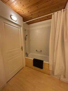 y baño con bañera y cortina de ducha. en Appart Risoul 1min pistes - PMR 4-6 pers, en Risoul 16 fotos más
