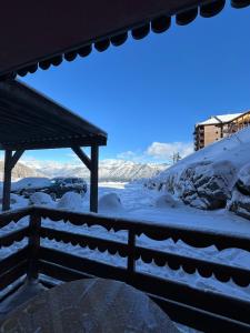 un patio cubierto de nieve con una valla y un coche en Appart Risoul 1min pistes - PMR 4-6 pers, en Risoul
