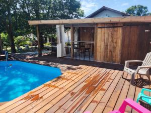 a deck with a bar and a swimming pool at Chambres d'hotes Les sables Blancs in Saint-Julien-en-Born