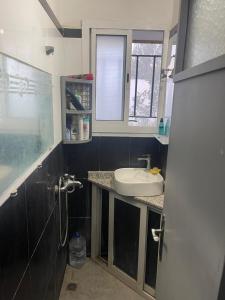 a small bathroom with a sink and a window at Achraf Immo in Fez
