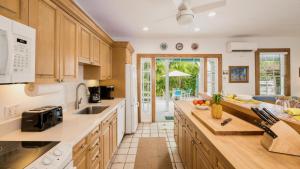 a kitchen with wooden cabinets and a counter top at Casa Serendipity by Last Key Realty in Key West