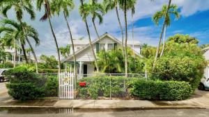a house with palm trees and a white gate at Casa Serendipity by Last Key Realty in Key West +30 photos