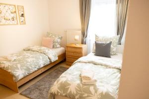 ein Schlafzimmer mit zwei Betten und einem Fenster in der Unterkunft Große schöne Ferienwohnung mit kleinem Garten im Weinort Randersacker in Randersacker