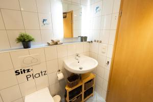 ein Badezimmer mit Waschbecken, Toilette und Spiegel in der Unterkunft Große schöne Ferienwohnung mit kleinem Garten im Weinort Randersacker in Randersacker + 20 Fotos