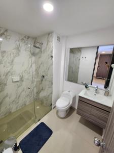 a bathroom with a toilet and a shower and a sink at Increíble apartamento con vista panorámica al lago Sochagota in Paipa