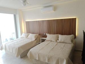 een hotelkamer met twee bedden en een raam bij SKY Acapulco Y condominio mediterrane in Acapulco +73 foto's