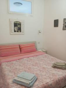 a bedroom with a pink bed with two towels on it at Tigullio Vacations in Leivi