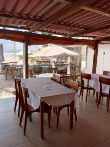 a dining room with a table and chairs and an umbrella at Escape villa assouinde in Assinie +29 photos