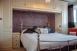 Un dormitorio con una cama grande y una pared. en Spacious 5-Bed Detached Home in Charming Tadcaster, en Tadcaster