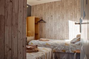 Dos camas en una habitación con paredes de madera. en Spacious 5-Bed Detached Home in Charming Tadcaster, en Tadcaster