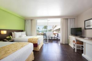 a hotel room with a bed and a tv at Emporio Mazatlan in Mazatlán