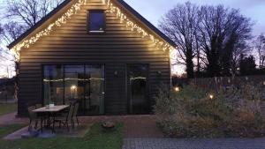 una casa con tavolo, sedie e luci di B&B Aan de Lankeren -exclusief ontbijt- a Voorthuizen