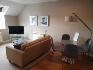 a living room with a couch and a table at Bowness On Windermere, Excellent Apartment For 4 With Parking in Bowness-on-Windermere