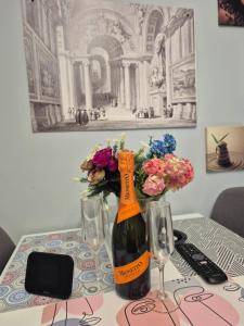 クラヨーヴァにあるMASHA Luxury New Apartment in the centerのワイン1本、花瓶1本
