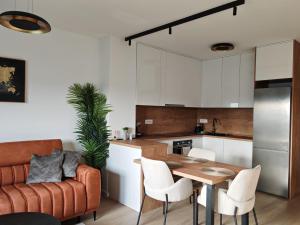 a kitchen and living room with a table and a couch at Apartman JOLE in Velika Gorica
