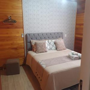 Un dormitorio con una cama grande con almohadas rosas. en Casas de Hospedagem Mendes, en Urubici