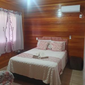 Un dormitorio con una cama con dos zapatos encima. en Casas de Hospedagem Mendes, en Urubici