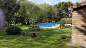 a picnic table in the grass next to a pool at La Gondromière 79140 CERIZAY in Cerizay