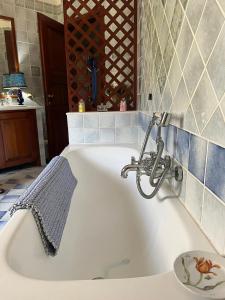 een bad met een kraan in de badkamer bij La quercia in Poggio Dei Pini +8 foto's