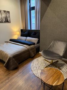 a living room with a bed and a chair at Ferienoase am Wasser in Idar-Oberstein
