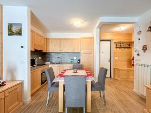 eine Küche und ein Esszimmer mit Tisch und Stühlen in der Unterkunft Aprica , Lusso a 300m dalle Piste da Sci, Garage Privato e Deposito Sci Gratuito in Le Bratte