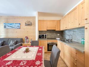 eine Küche mit einem Tisch und einem roten Tischtuch in der Unterkunft Aprica , Lusso a 300m dalle Piste da Sci, Garage Privato e Deposito Sci Gratuito in Le Bratte