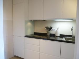 a kitchen with white cabinets and a sink at Apartamentos Rurales Entre Fuentes in Cuacos de Yuste +39 photos