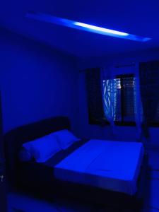 a blue room with a bed with a blue light at VILLA Emiliana SABADELL in Yaoundé +12 photos