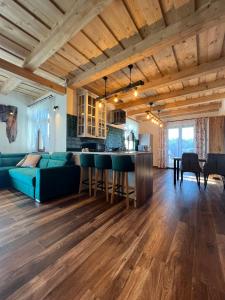 a living room with a blue couch and a bar at Julia Vendeghaz Fony in Fony