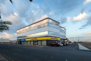 a large building with cars parked in front of it at Luma Serviced Apartments in Medina