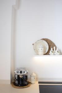 a kitchen counter with a coffee maker on a shelf at Dimora Lauré in Fasano