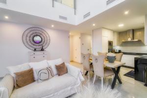 ein Wohnzimmer mit einer weißen Couch und einem Tisch in der Unterkunft Villa White Diamond - Piscine - Plage 10 minutes in Daya Vieja