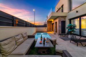 ein Wohnzimmer mit einem Sofa und einem Pool in der Unterkunft Villa White Diamond - Piscine - Plage 10 minutes in Daya Vieja