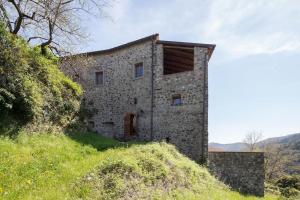 an old stone building on a grassy hill at appartamento in casa medievale in Aulla