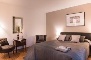 1 dormitorio con 1 cama, 2 sillas y espejo en Parkside Apartment House en Düsseldorf