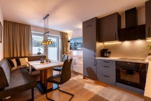 a kitchen with a table and a dining room at Appartement Maria Theresia in Hopfgarten im Brixental