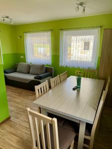 een woonkamer met een tafel, stoelen en een bank bij Domki Letniskowe Konik 3 in Radków +2 foto's