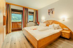 una camera da letto con un grande letto in legno con cuscini bianchi di Haus Binter a Weissensee