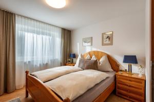 a bedroom with a large bed and a window at Appartement Maria Theresia in Hopfgarten im Brixental