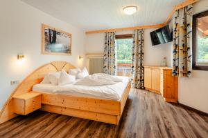 una camera con letto in legno e TV di Haus Binter a Weissensee