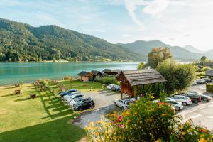 un gruppo di auto parcheggiate in un parcheggio vicino a un lago di Haus Binter a Weissensee