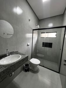 a bathroom with a toilet and a sink and a shower at Kitnet de 2 quartos no Jardim dos Ipês in Sorriso