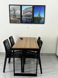 a wooden table and chairs in a room with pictures on the wall at Kitnet de 2 quartos no Jardim dos Ipês in Sorriso